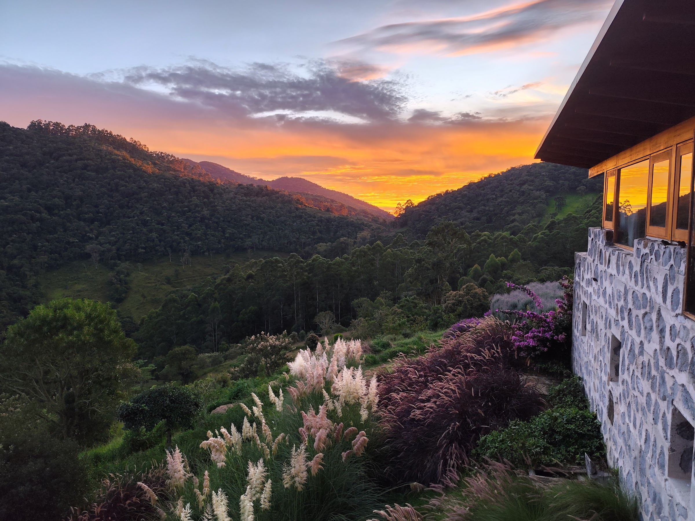 Jardim, mata e montanhas ao pôr do sol junto à Casa 23.44